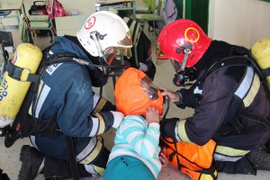 Bomberos de Protección Civil atienden a una de las "víctimas" del incendio.  
